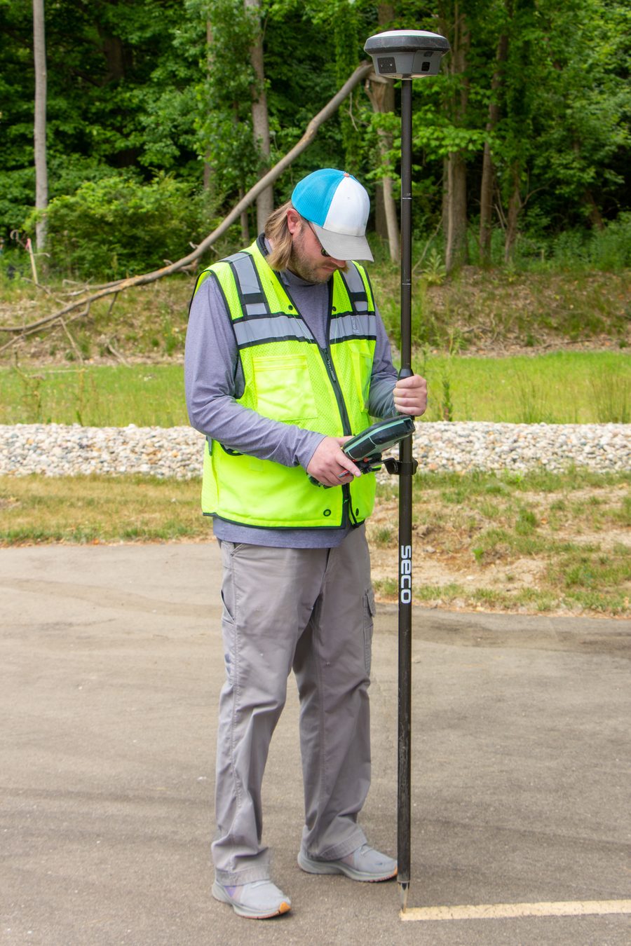 Surveyor holding a GNSS RTK rover pole in the field